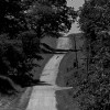 black and white photo of a country road